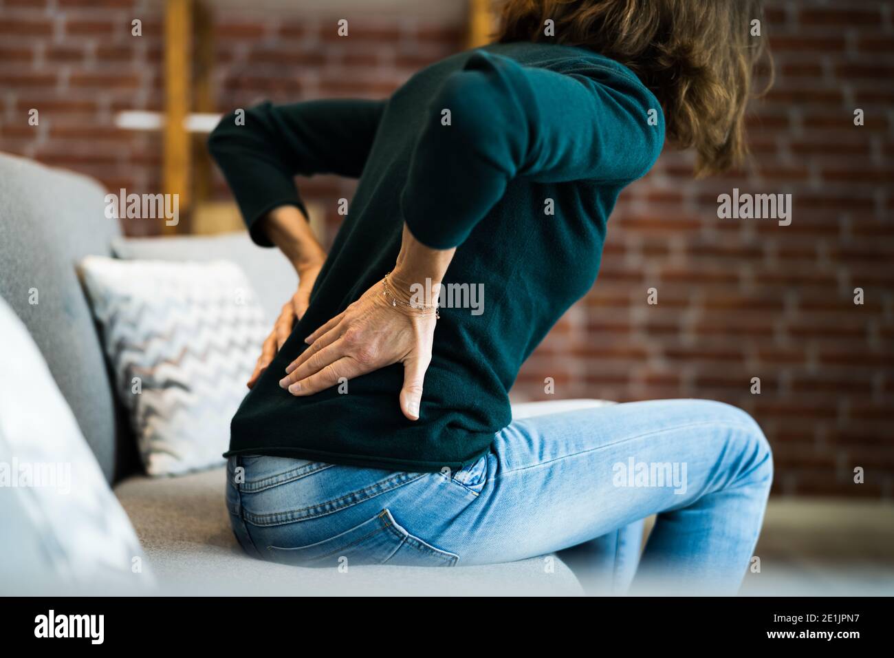 Mujer con dolor de espalda y Ache. Mala postura Foto de stock