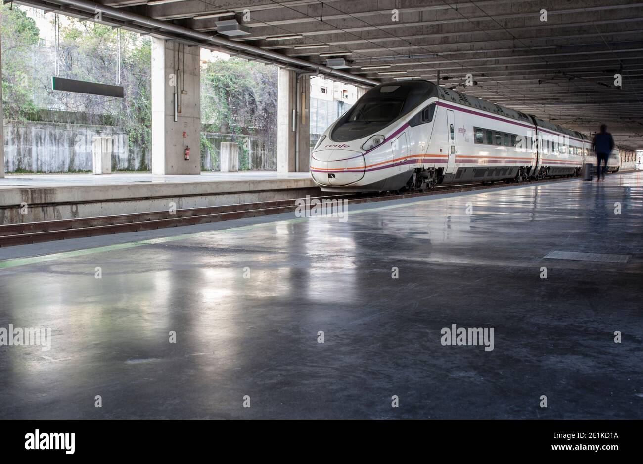 El viajero se acerca al tren en la estación de tren de alta velocidad española Foto de stock