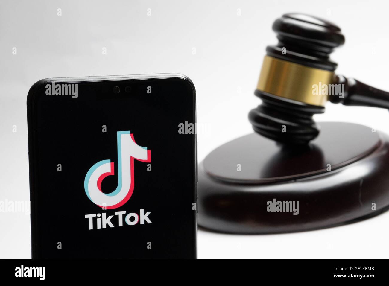 Stafford, Reino Unido - 7 de enero de 2021: El logo de Tiktok visto en el teléfono inteligente y un juez gavel borroso en el fondo. Concepto. Foto de stock