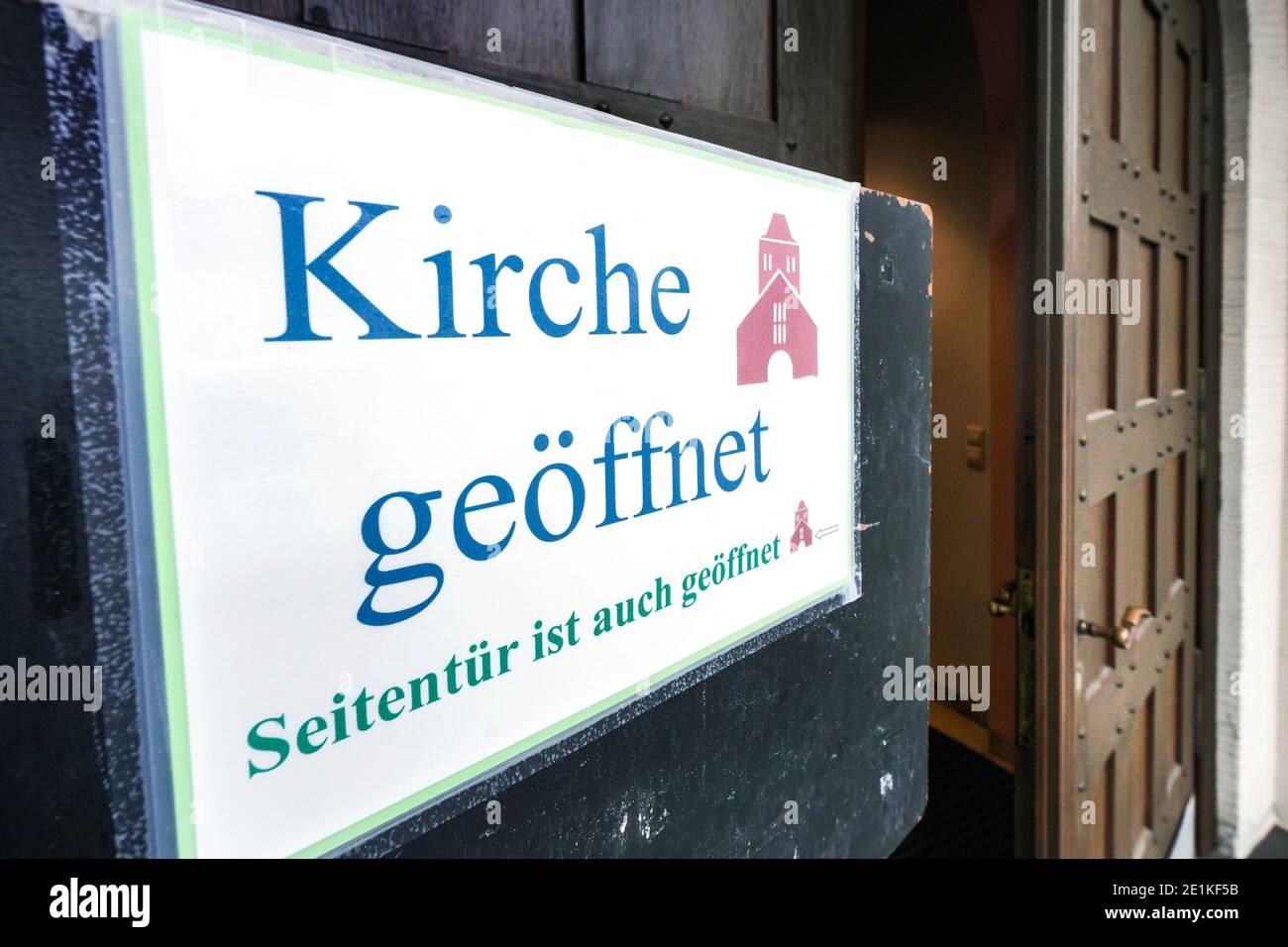Schir an der Tür der katholischen Franziskus-Xaverius-Kirche en Dortmund weist darauf hin, dass die Kirche auch während der Maßnahmen zum Corona-Lockdown geöffnet ist. Foto de stock