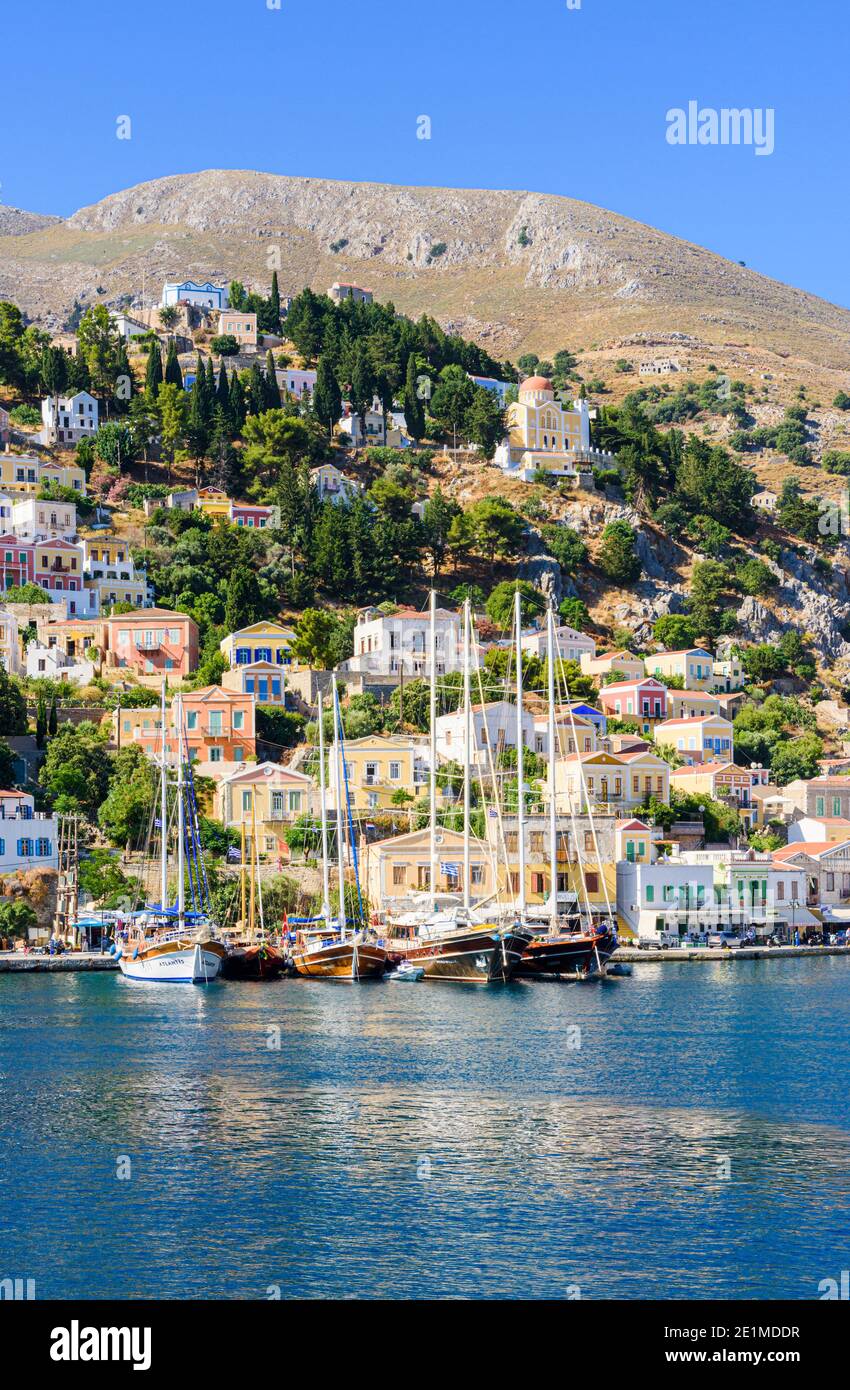 Isla Symi vistas de los barcos amarrados a lo largo de la costa de la ciudad de Gialos en la isla de Symi, Dodecaneso, Grecia Foto de stock