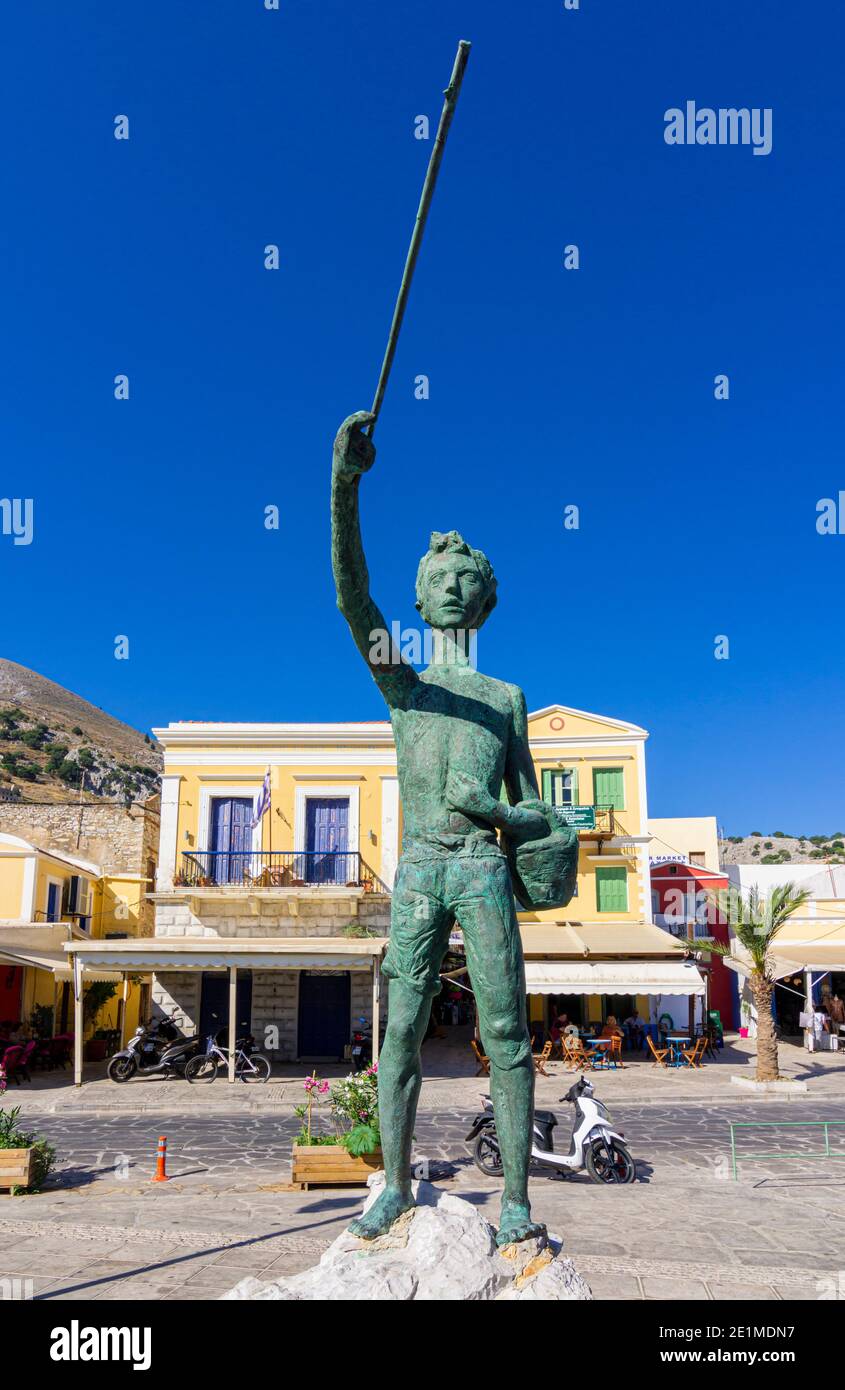 El pequeño pescador Michalaki estatua a lo largo de la orilla del puerto de Gialos, Isla Symi, Dodecaneso, Grecia Foto de stock
