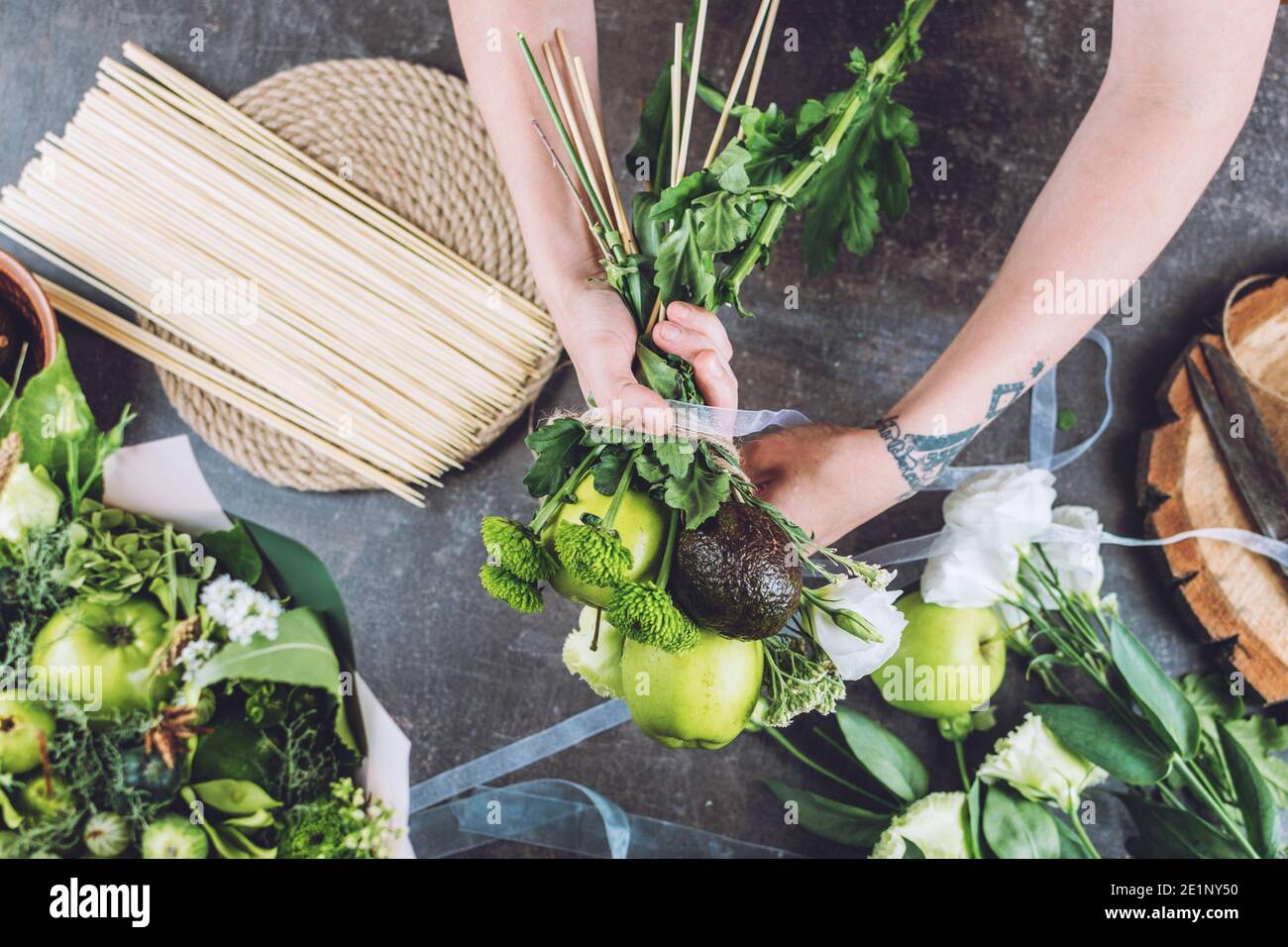 Pasatiempos y actividades, artes y artesanías durante el coronavirus. Floristería mujer hacer fruta ramo comestible. Naturalidad, arreglos florales, trucos floristería Foto de stock