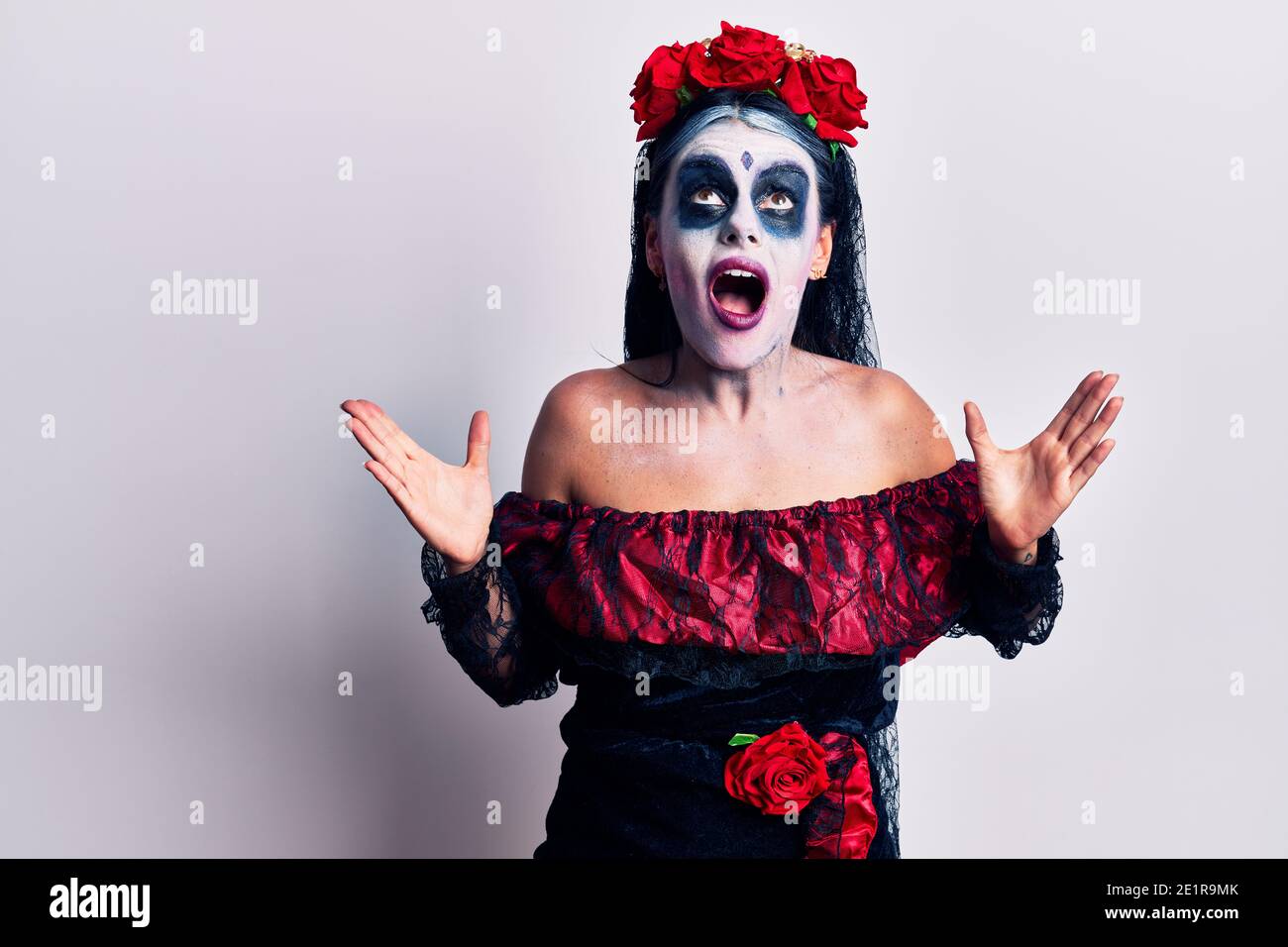 Mujer joven con el día mexicano de los muertos maquillaje loco y loco  gritando y gritando con expresión agresiva y los brazos levantados.  Concepto de frustración Fotografía de stock - Alamy