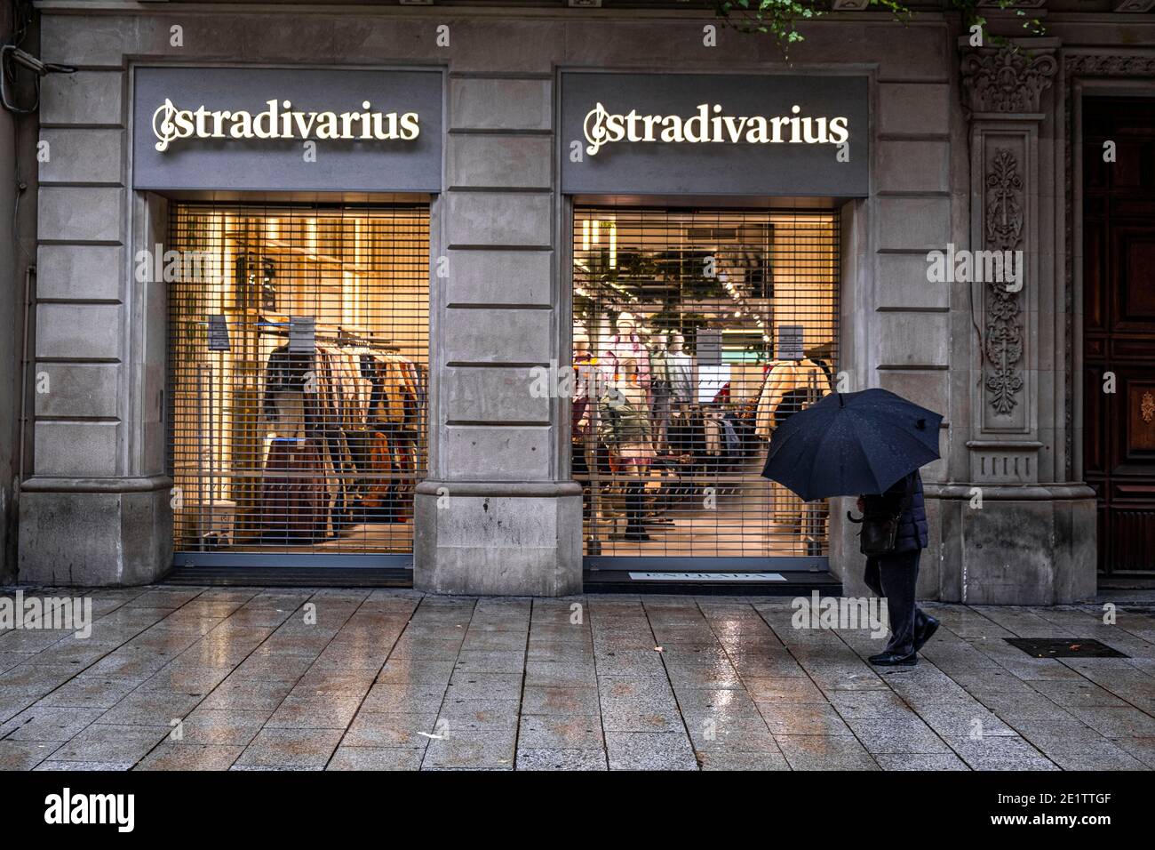 Un con un paraguas visto caminando por la zona comercial del Portal de l'Àngel tiendas cerradas excepto esenciales.debido a un aumento en las Covid-19, Barcelona sufre de nuevo