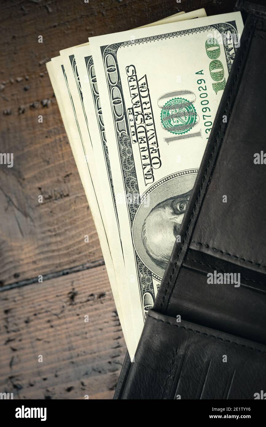 Cartera de cuero llena de dinero en mesa de madera - cien billetes de  EE.UU. Con el presidente Franklin retrato. Efectivo de billetes de cien  dólares, moneda de papel Fotografía de stock -
