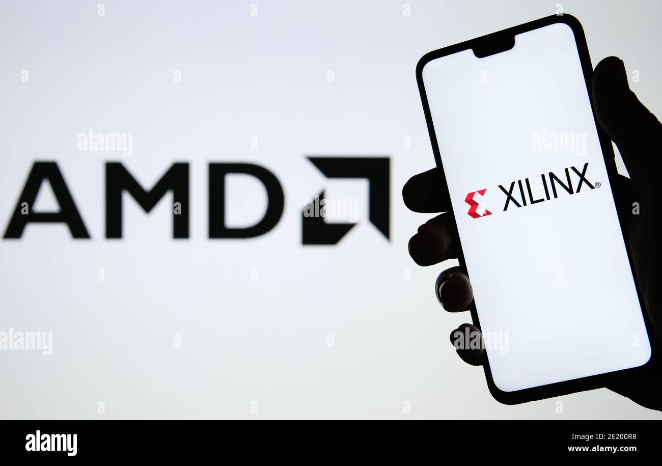 Manchester / Reino Unido - 21 de octubre de 2020: AMD para adquirir Xilinx, concepto. XILINX logotipo visto en la silueta de smartphone en una mano y blurre Foto de stock