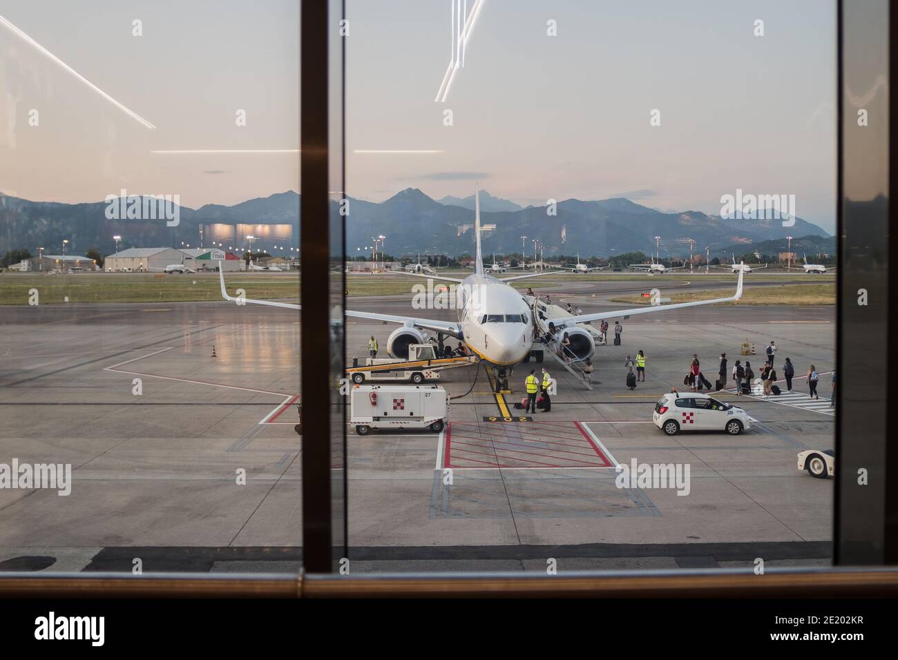 Gente esperando en cola en la zona de embarque del aeropuerto internacional de Milán Bergamo. Concepto de viajes y turismo en tiempos de coronavirus Covid-19. Foto de stock