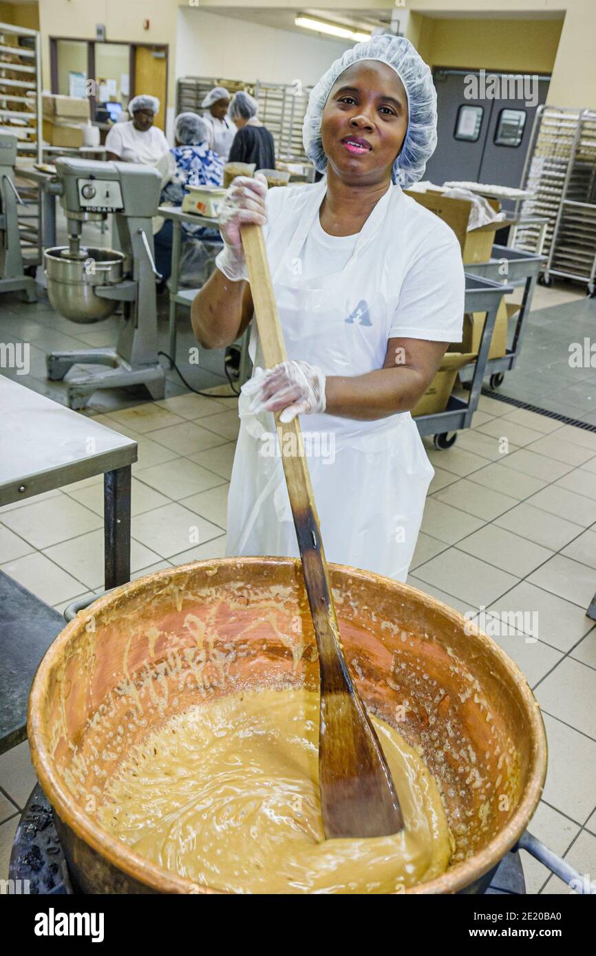 Alabama Fort Deposit Priester's Pecans fabricante de dulces, mujer negra trabajadora de producción empleada de trabajo mezclando batter, Foto de stock