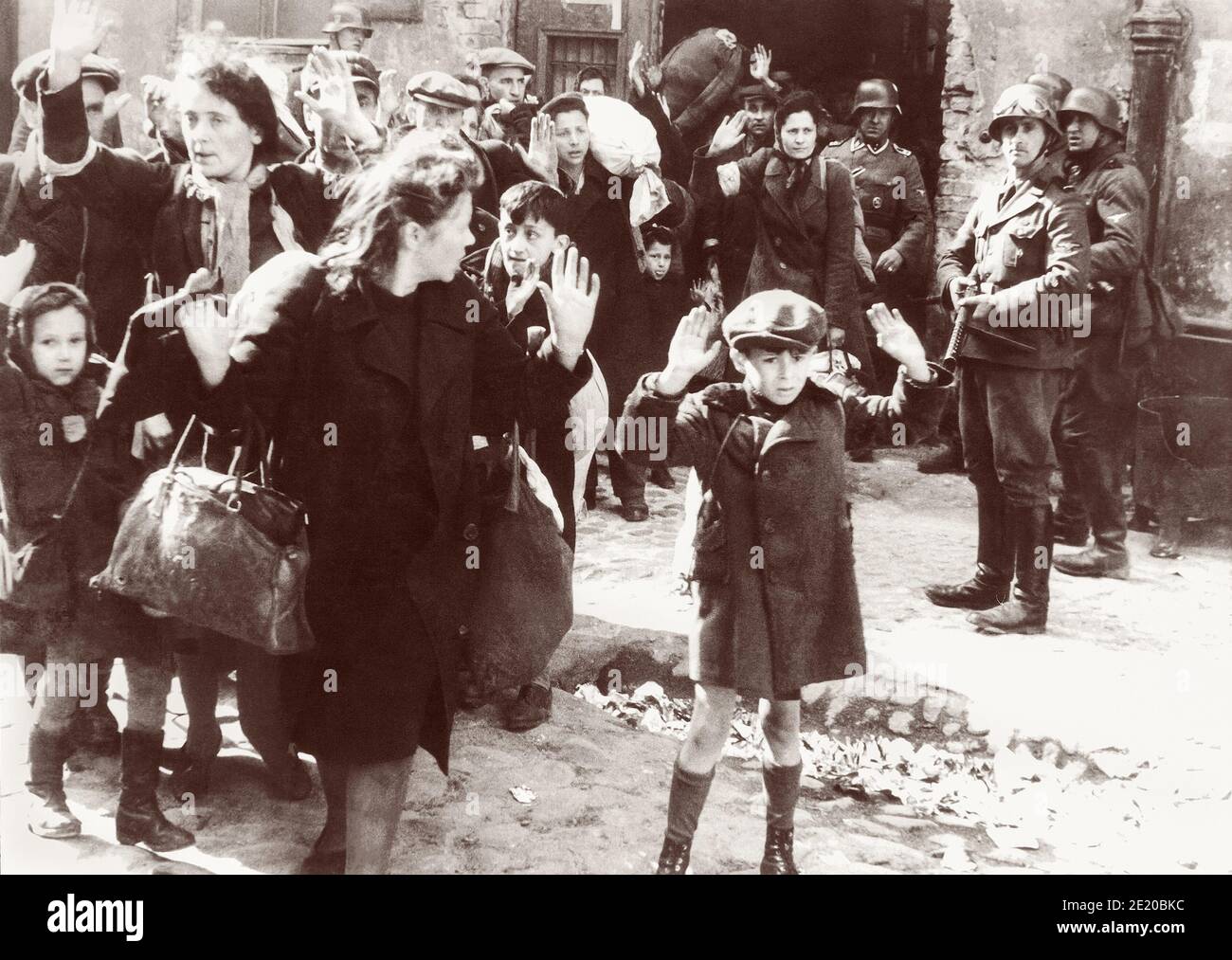 Un niño levanta las manos sobre su cabeza mientras los soldados nazis sacan por la fuerza a los judíos polacos en el levantamiento del gueto de Varsovia para ser transportados en tren al campo de exterminio de Majdanek o Treblinka. Una de las fotografías más emblemáticas de la Segunda Guerra Mundial, la imagen, probablemente de abril o mayo de 1943, fue incluida en el Informe Stoop que las SS y el líder de la Policía Jürgen Stroop le dieron a Heinrich Himmler. Foto de stock