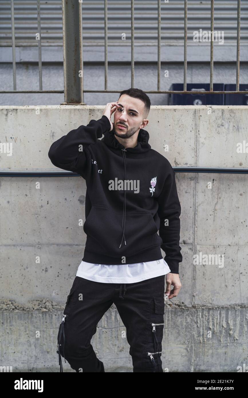 Disparo vertical de un joven hombre de moda posando en un ropa de calle  negra Fotografía de stock - Alamy