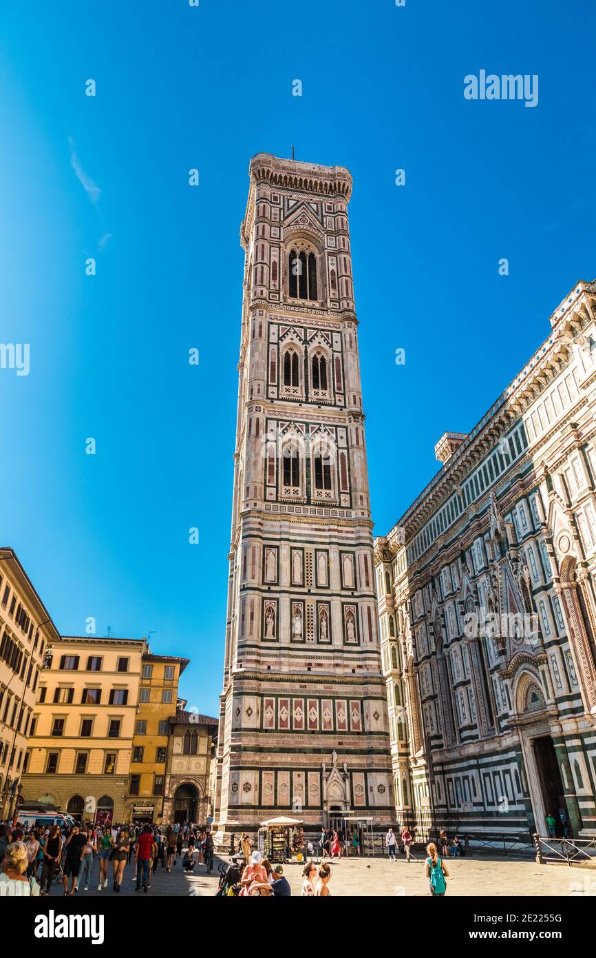Hermosa vista completa del famoso Campanile de Giotto desde el lado este con la puerta de entrada. El campanario independiente es parte de la... Foto de stock