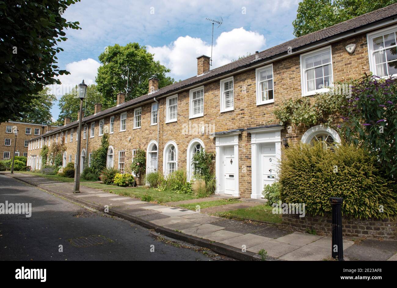 Fila de casas adosadas neo georgianas de dos pisos que muestran atractivos jardines frontales, Hopping Lane, Canonbury, Borough de Islington en Londres Foto de stock