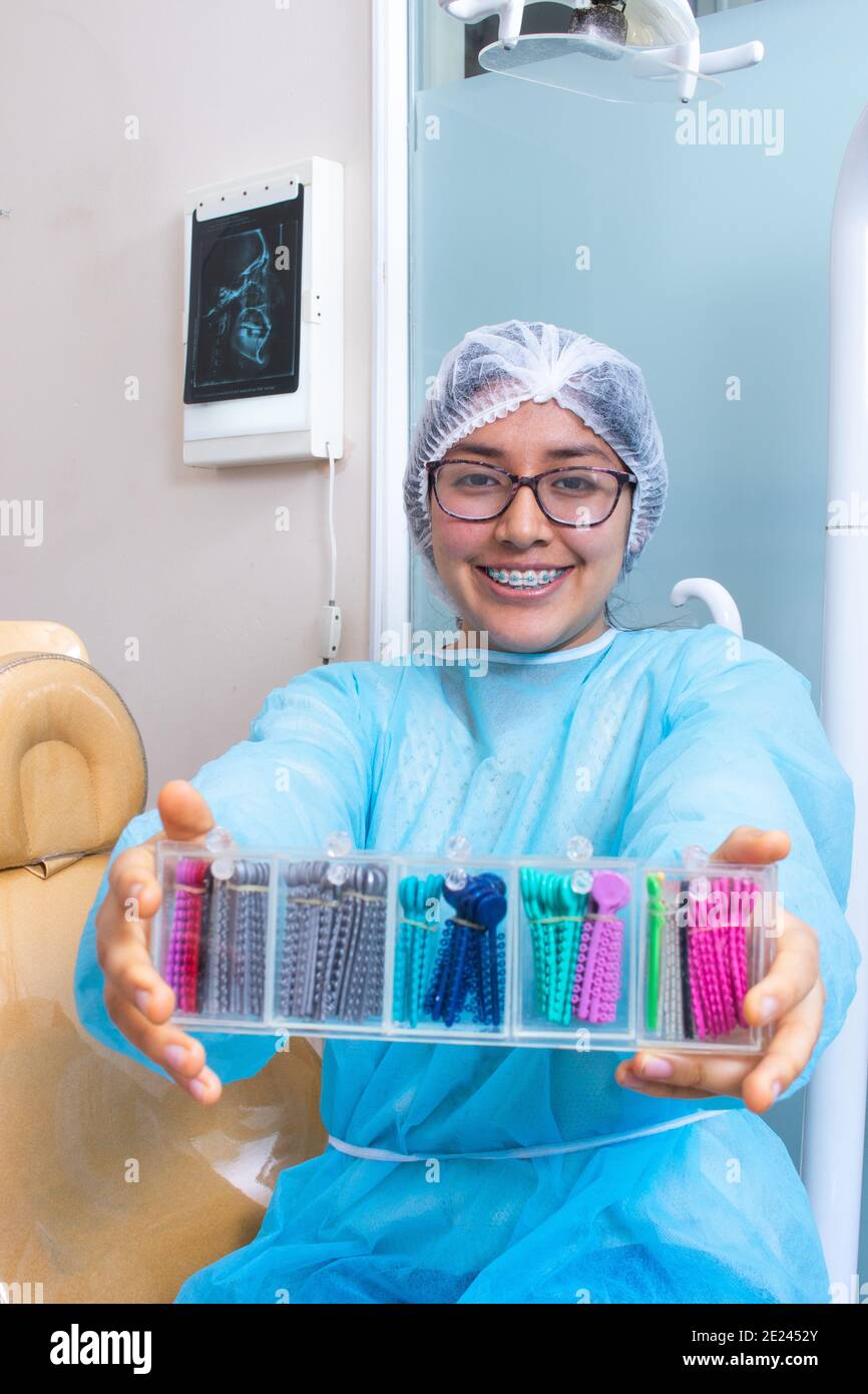 Paciente sosteniendo un recipiente lleno de bandas de goma elastomérica  ortodoncia para tratamiento dental Fotografía de stock - Alamy