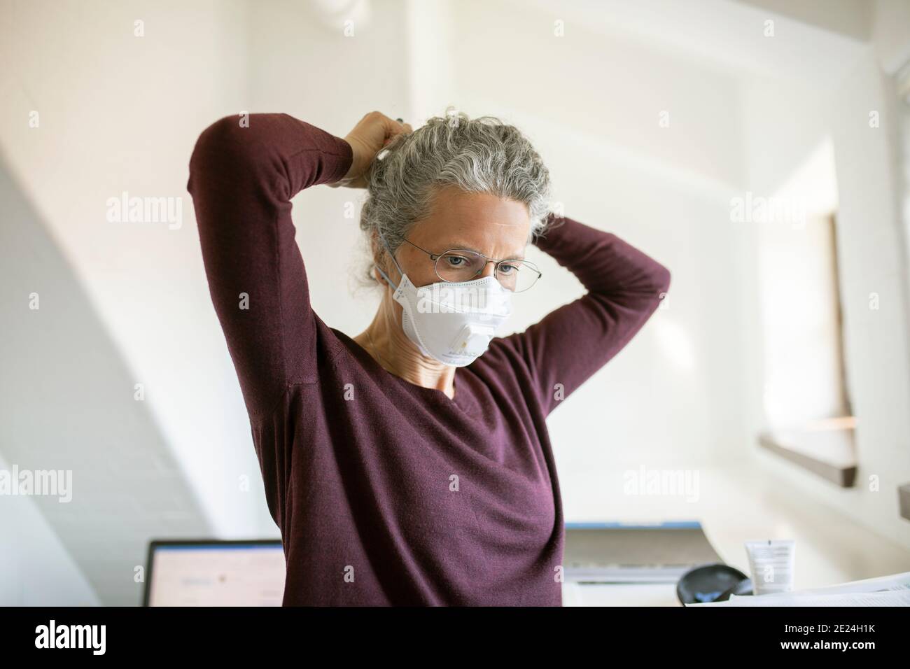 Mujer poniendo máscara protectora Foto de stock