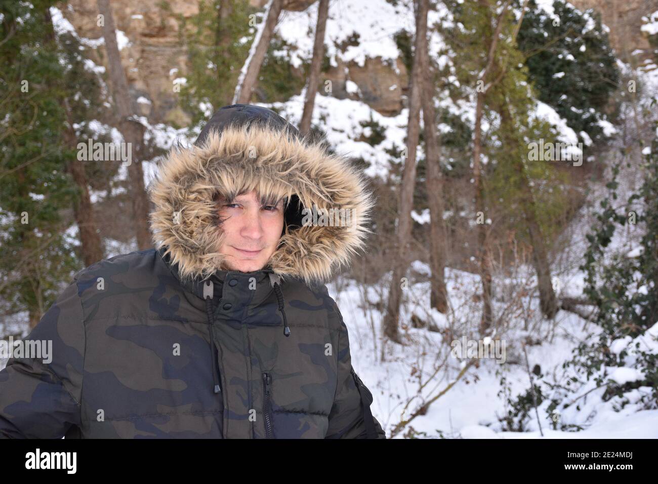 D a de la nieve hombre con chaqueta de color militar y capucha