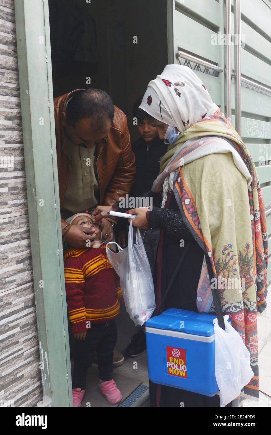 Un trabajador sanitario paquistaní administra una vacuna contra la polio a un niño Durante una campaña puerta a puerta de vacunación contra la polio en Lahore Foto de stock