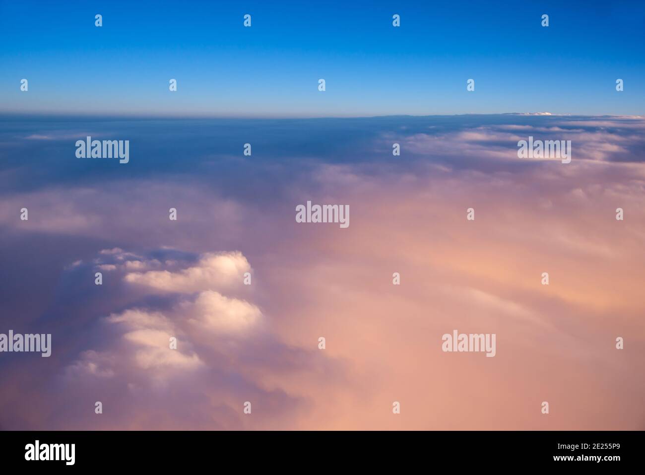 Vista sobre el cielo y las nubes desde la puerta de un avión al atardecer Foto de stock