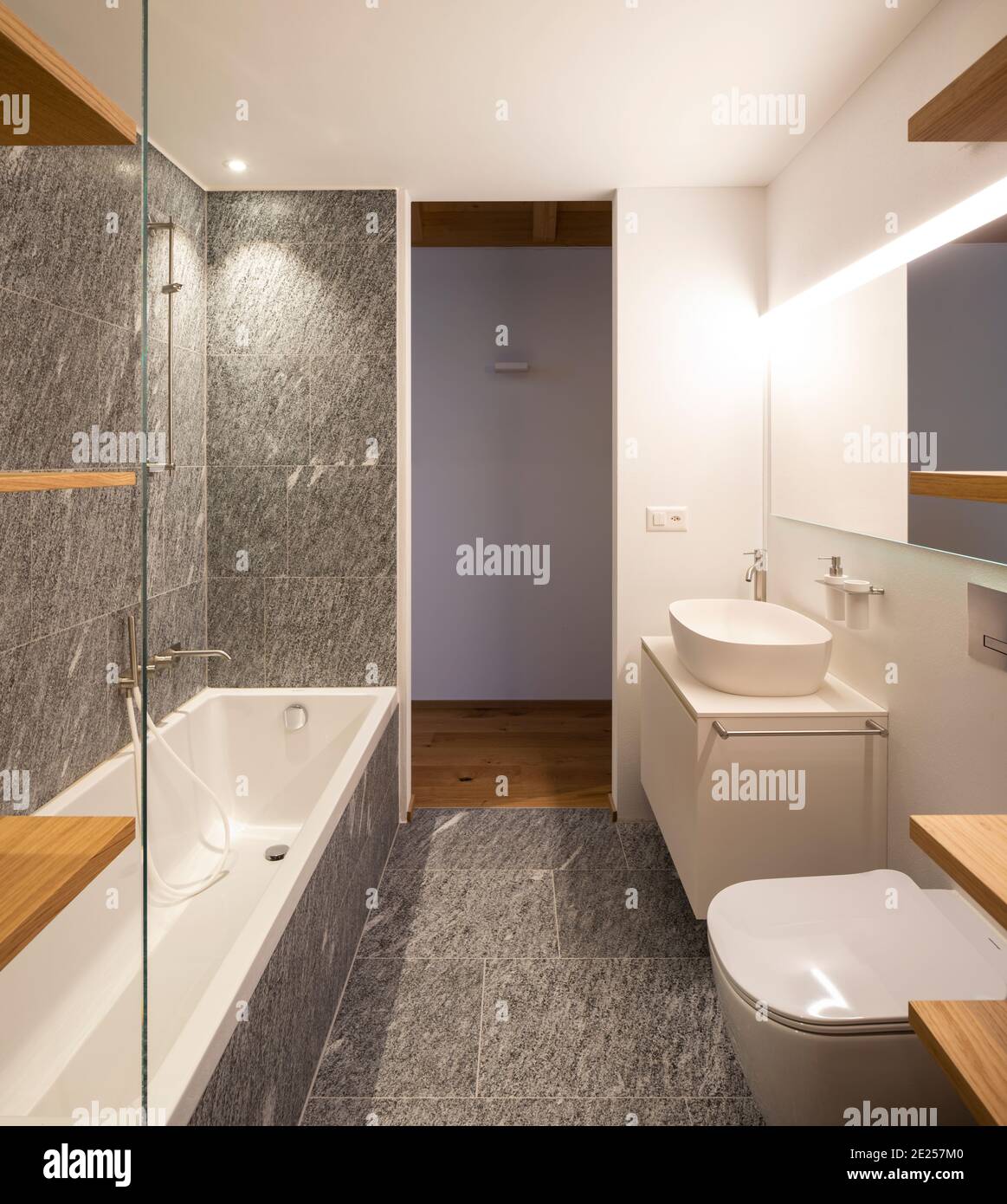 Interior moderno con paredes blancas y pisos de madera. Baño moderno con madera y piedra, minimalista. Nadie dentro Foto de stock