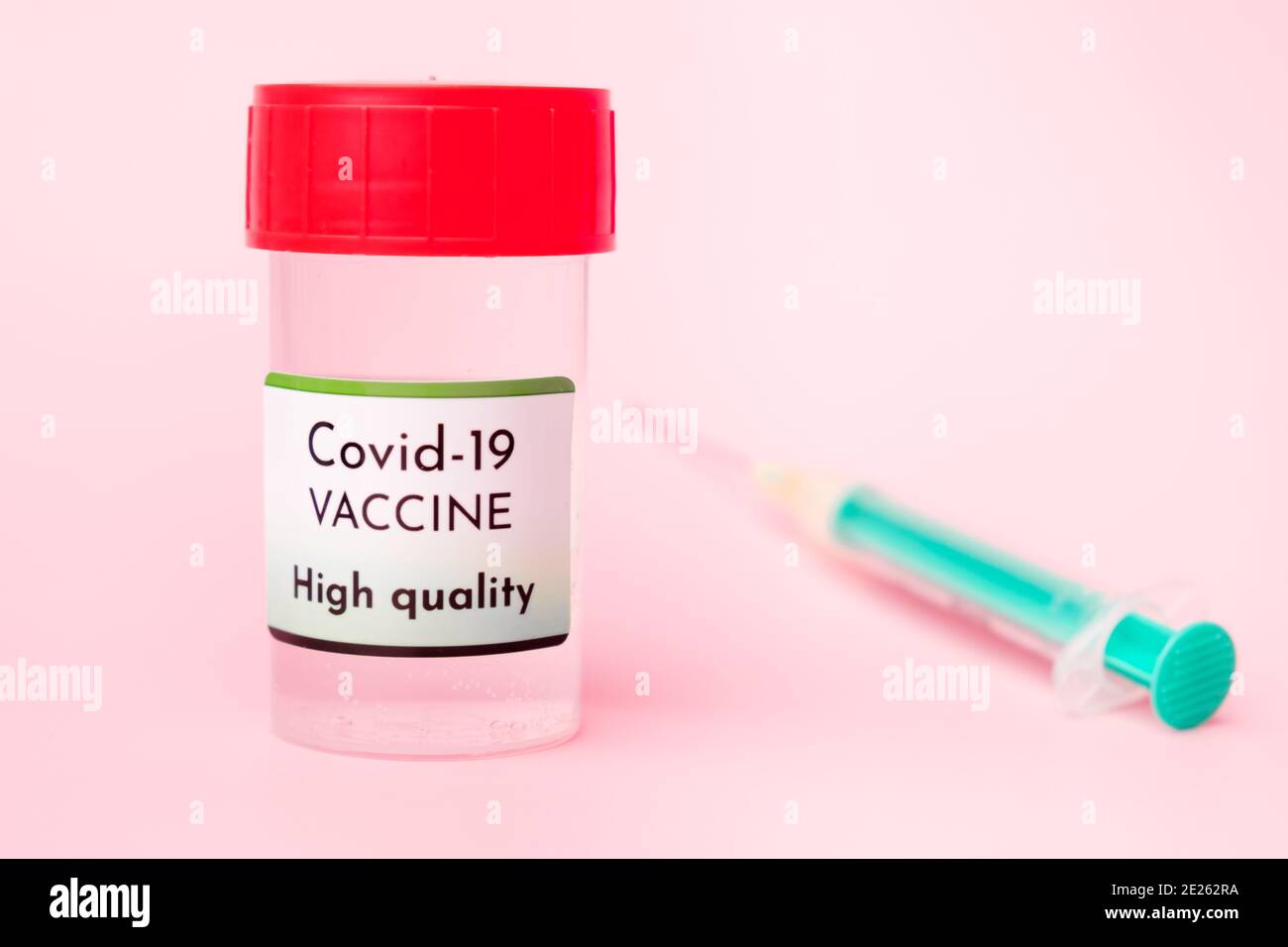 Vacuna Covid-19 de alta calidad en botella y jeringa desechable para inyección sobre fondo rosa. Prevención del coronavirus, Sars-CoV-2. Foto de stock
