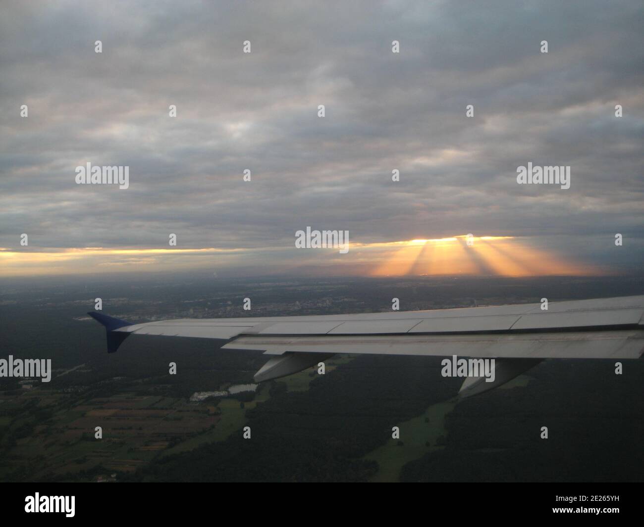puesta de sol entre nubes desde arriba desde una ventana de avión Foto de stock