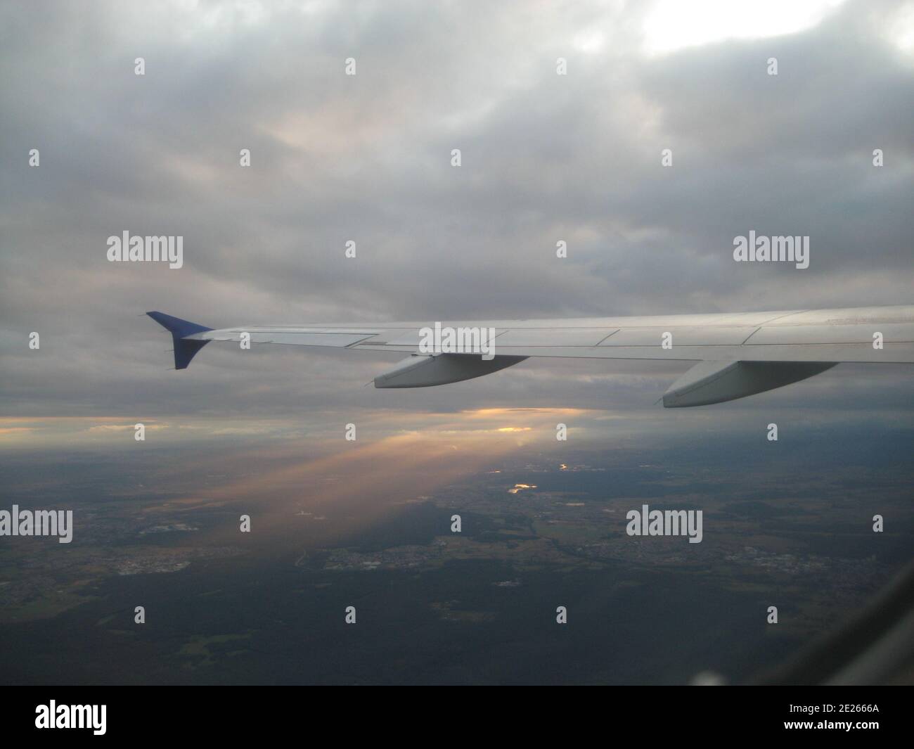 puesta de sol entre nubes desde arriba desde una ventana de avión Foto de stock