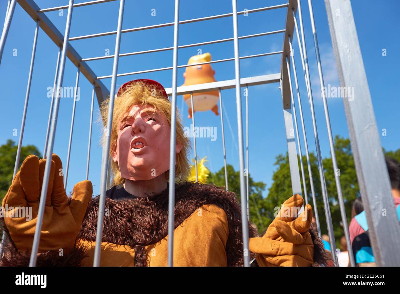 Protestor en una jaula vestida como Donald Trump en un Traje de gorila en la Plaza del Parlamento durante una visita oficial El Presidente de los Estados Unidos en Londres Foto de stock