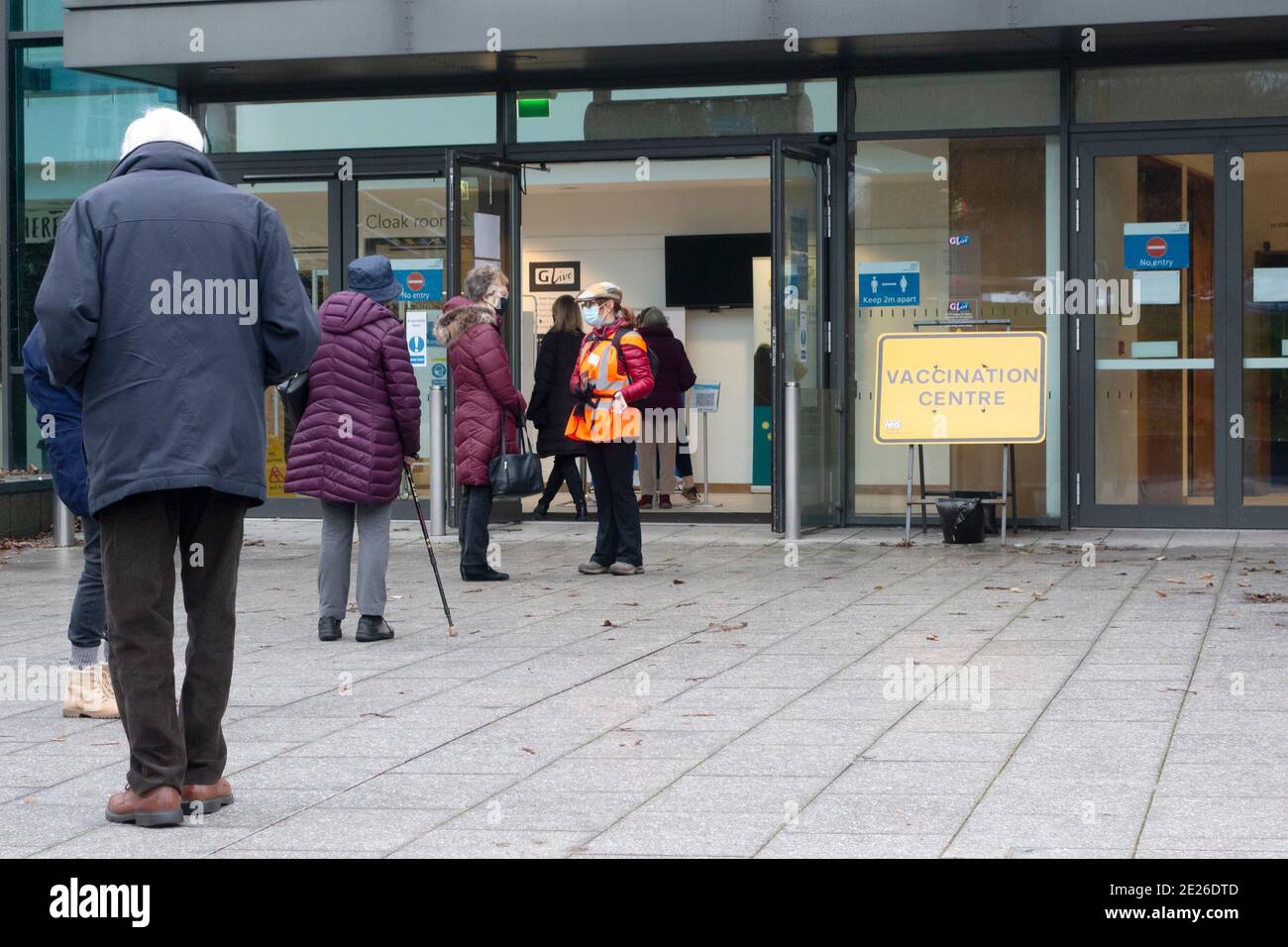 La gente se coloca fuera de la sede del evento G Live en Guildford, Surrey, Reino Unido, el primer día de las vacunas Covid 19 en la sede del 12 de enero de 2021. Los pacientes recibirán la vacuna Pfizer. Foto de stock