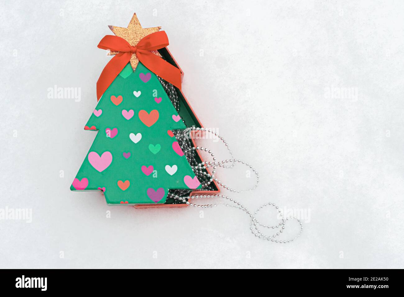 Caja de regalo en forma de árbol de Navidad. Y la piel de Navidad en la  nieve hay un lugar para el texto. Navidad, concepto de año Nuevo. Foto de  alta calidad