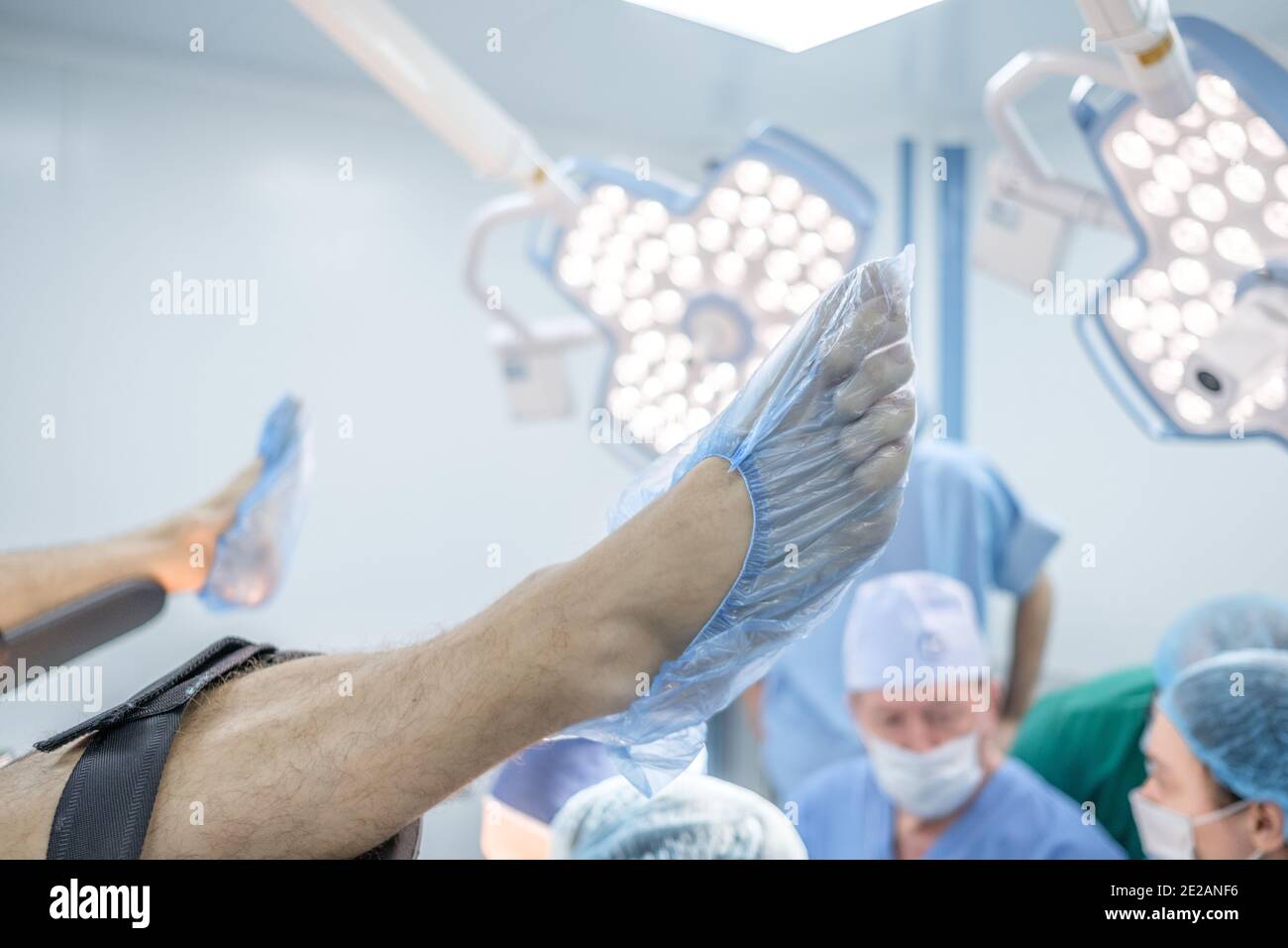 Las piernas del paciente en las cubiertas de los zapatos médicos se