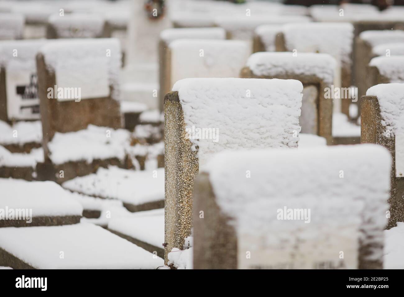 Lápidas en un cementerio judío durante un día de invierno frío y nevado. Foto de stock