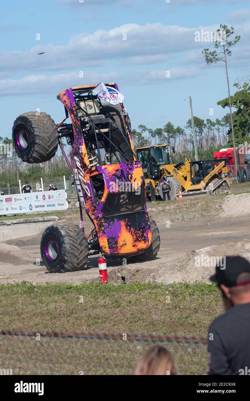 Un camión monstruo se desplaza sobre dos ruedas mientras se presenta en las carreras de camiones monstruo en Nápoles, Florida. Foto de stock