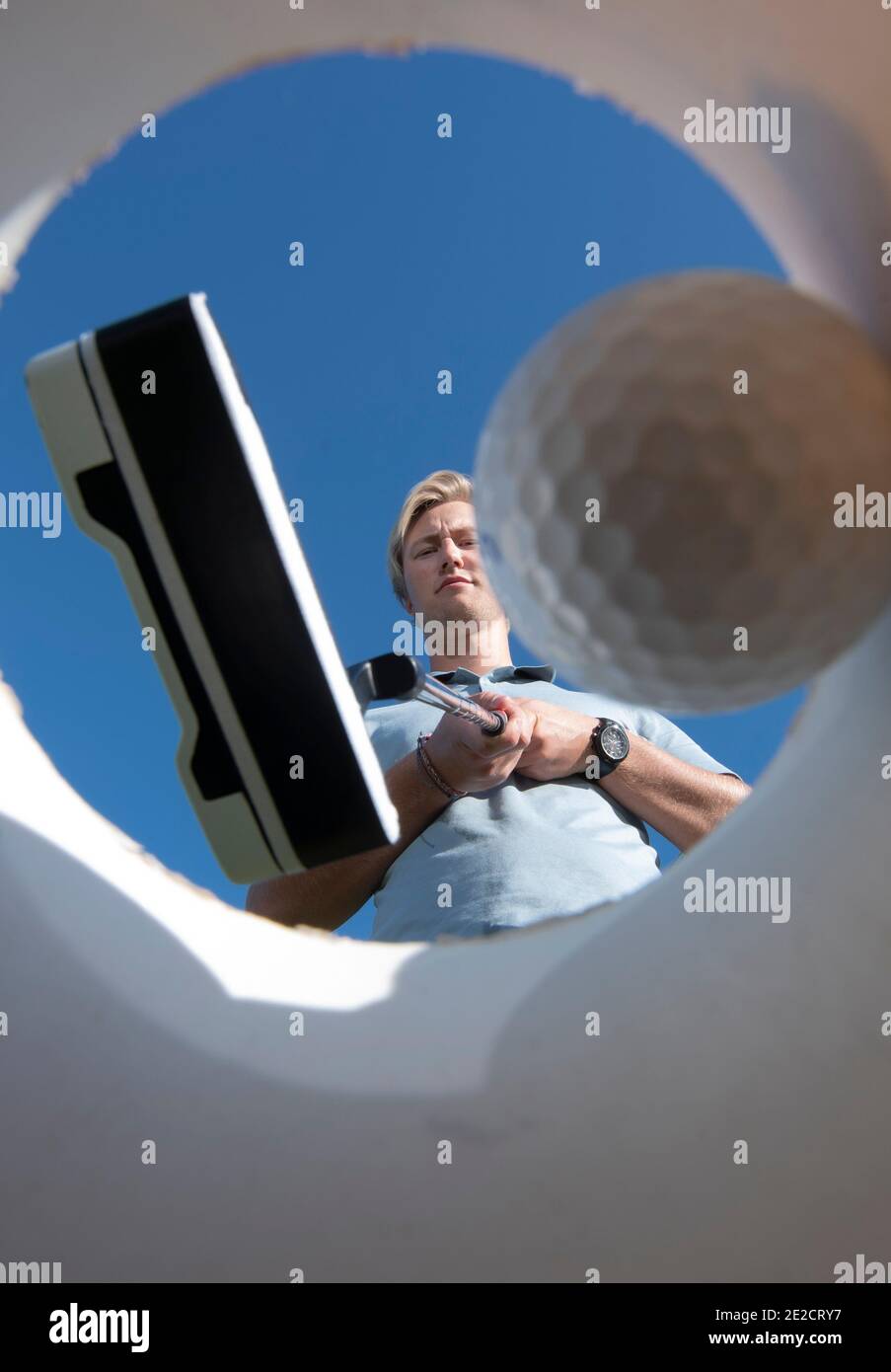 Un golfista pone su pelota en un lo que se supone que es una copa de golf en Rotonda West, Florida. Foto de stock