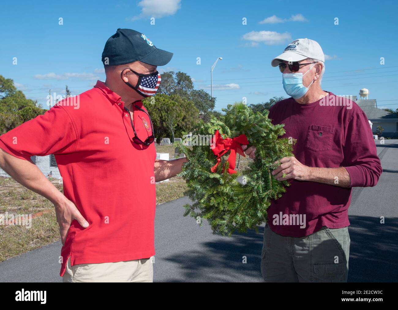 Dos veteranos intercambian una corona mientras celebran las Wreaths Across America en Englewood, Florida Foto de stock