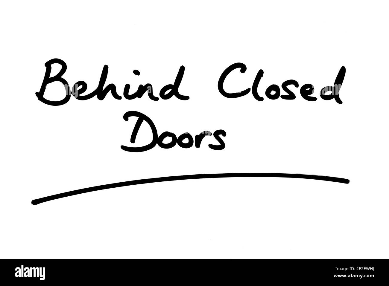 Detrás de puertas cerradas escritas a mano sobre un fondo blanco. Foto de stock