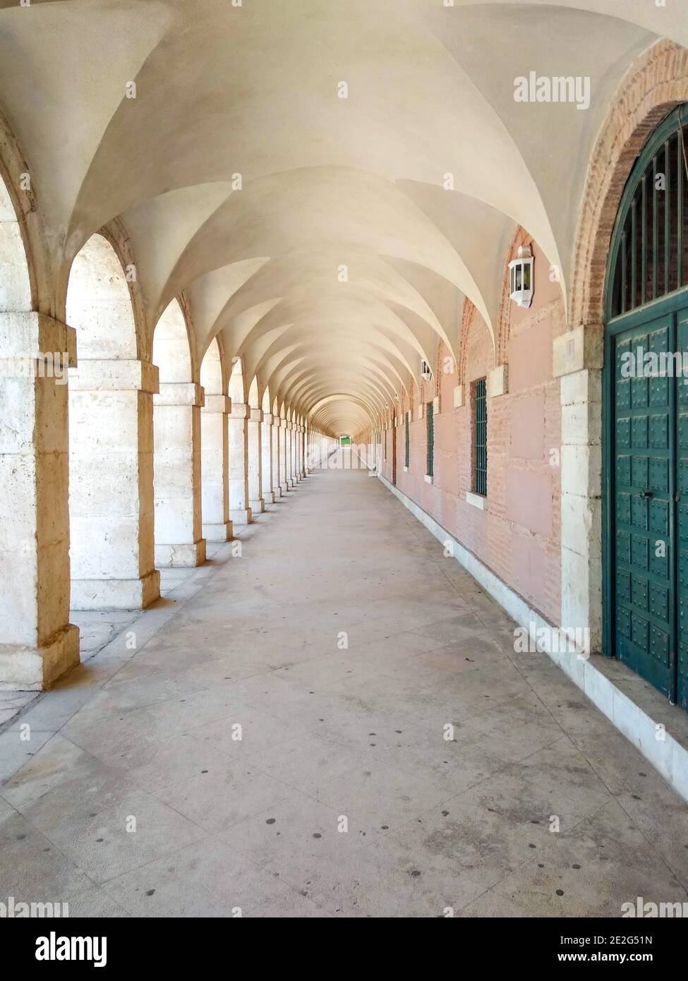 Palacio Real de Aranjuez con pasadizo arqueado que bordea la Plaza de  Parejas. El Palacio Real de Aranjuez es de arquitectura renacentista.  España Fotografía de stock - Alamy