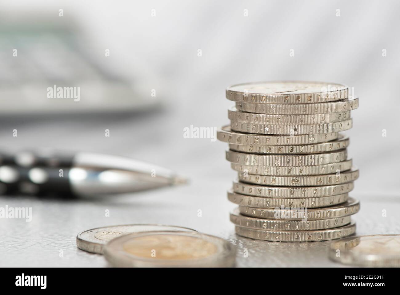 Stapel Euromünzen mit Rechner auf Börsenchart Foto de stock