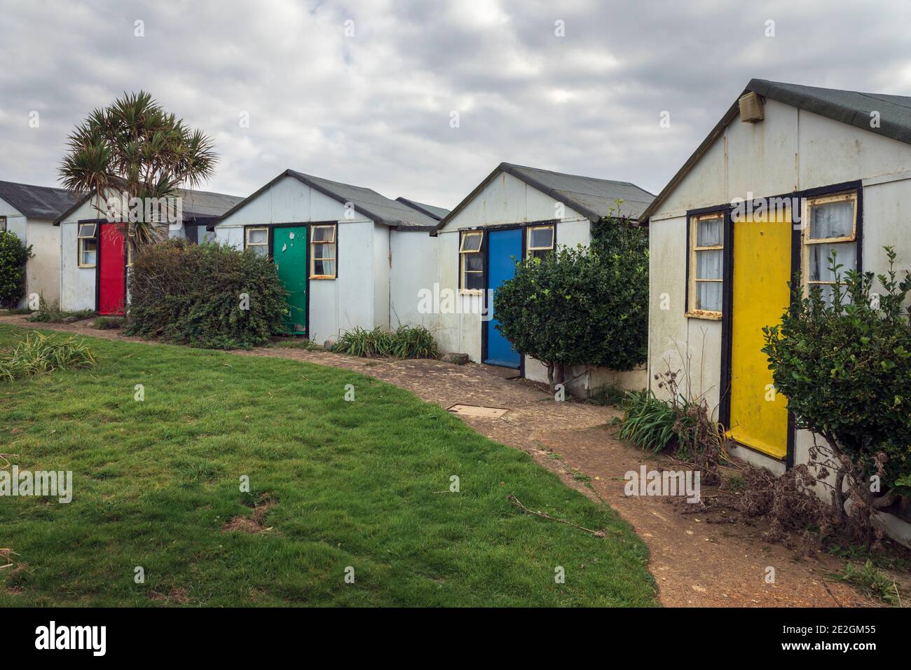 Puertas de colores brillantes en los chalets de vacaciones abandonadas debido a la erosión de los acantilados en Brightstone Bay, Isla de Wight Foto de stock