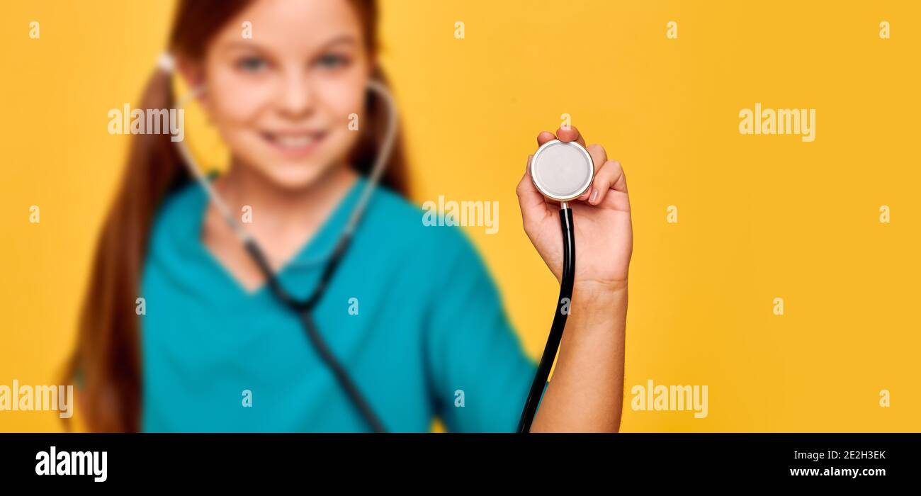 Estetoscopio en el primer plano de la mano de un niño. Hobby de los niños y profesión médica futura. Enfoque suave Foto de stock