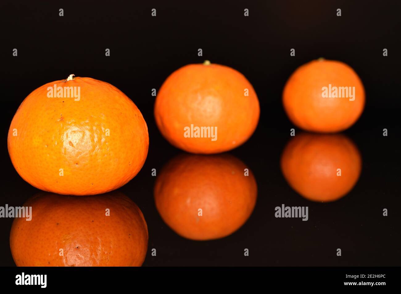 Unas cuantas tangerinas maduras de color naranja brillante sobre fondo  negro Fotografía de stock - Alamy