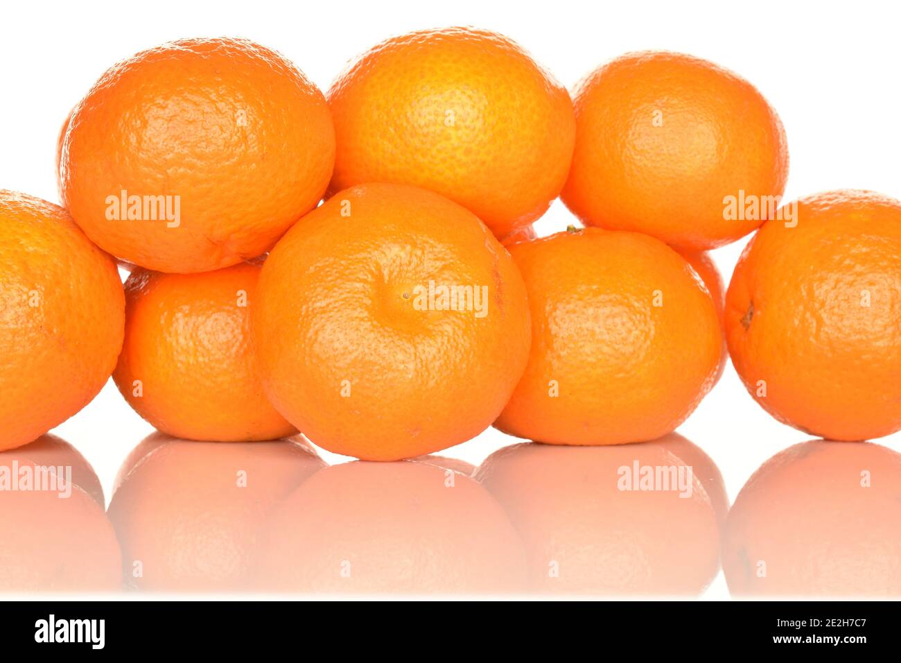 Unas cuantas tangerinas jugosas de color naranja brillante, sobre fondo  blanco. La mandarina más cercana, en primer plano en el foco Fotografía de  stock - Alamy