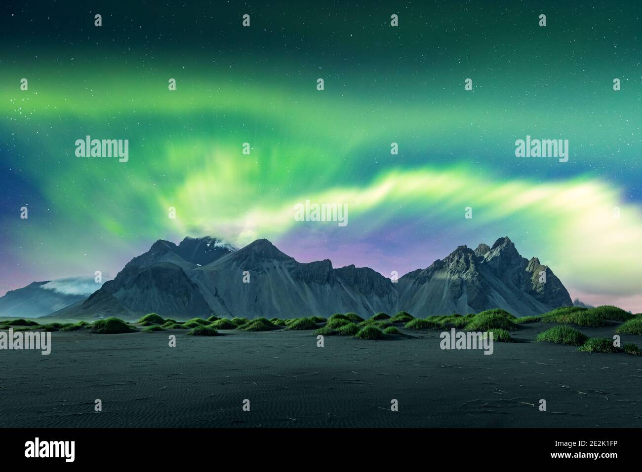 Aurora borealis aurora boreal luces sobre las dunas de arena negra del  desierto y los baches verdes cerca de las famosas montañas Stokksnes en el  cabo Vestrahn, Islandia. Fotografía de paisajes. Cortesía