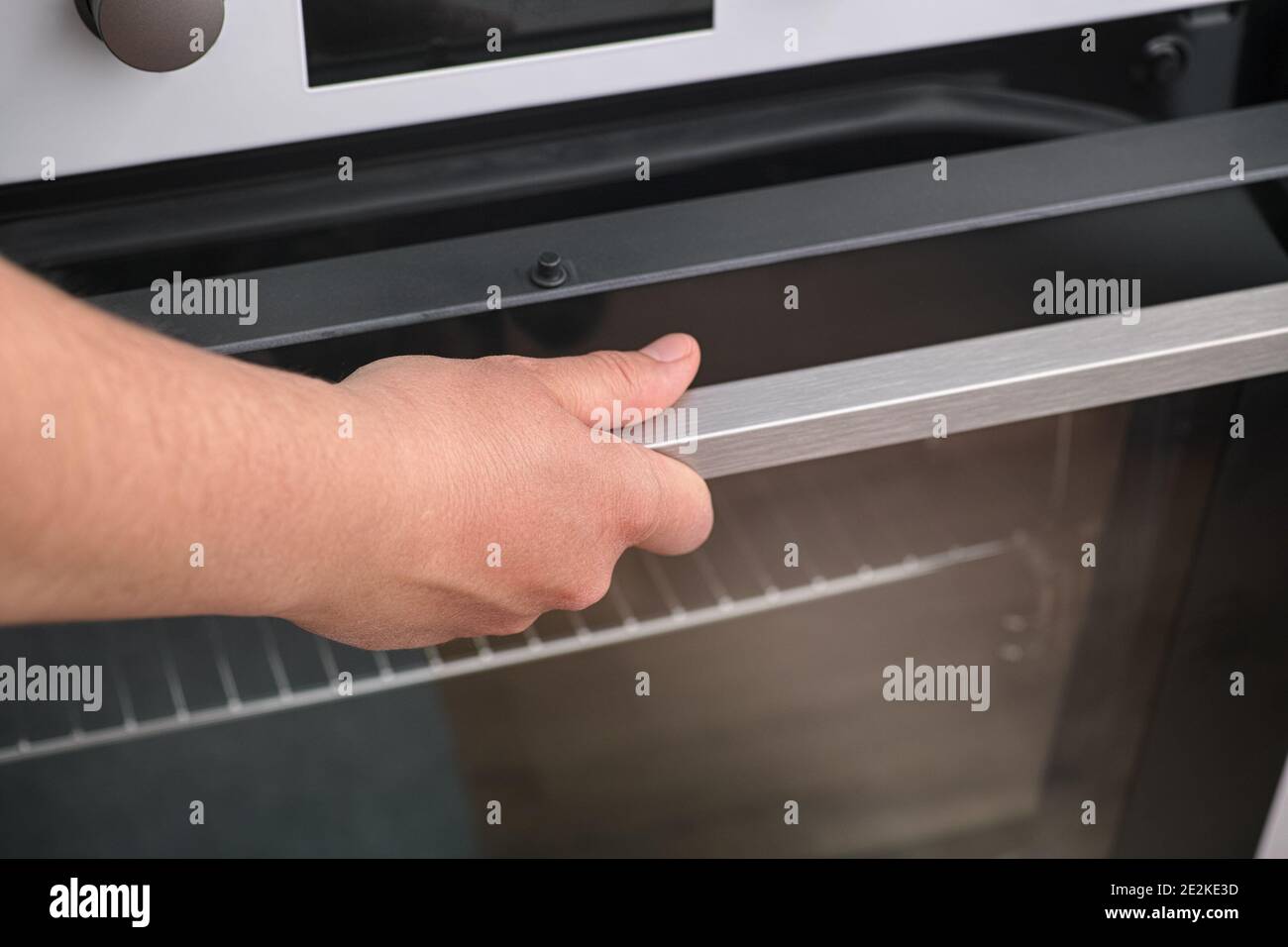 Mujer abriendo un horno. Profundidad de campo reducida. De cerca Fotografía  de stock - Alamy