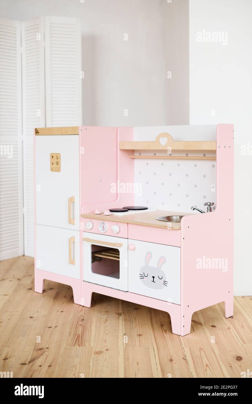 Muebles de juegos para niños. Cocina rosa pequeña dulce con nevera, cocina,  horno y fregadero en el espacio de copiado de la habitación Fotografía de  stock - Alamy