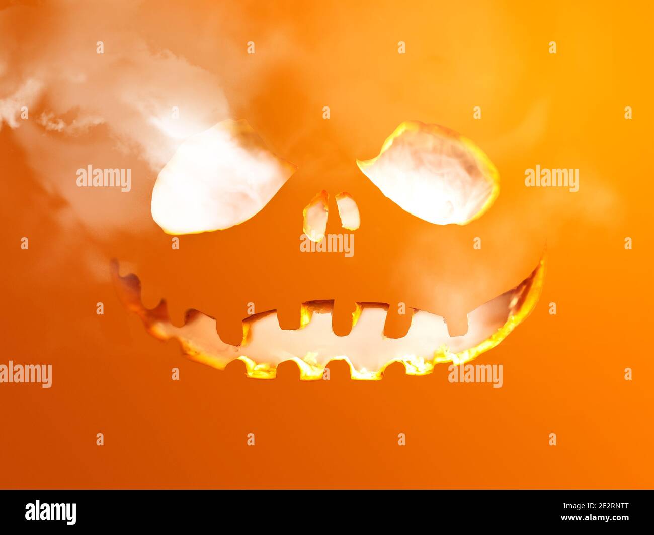 Halloween tema tallado agujero en una superficie plana con humo saliendo. Foto de stock