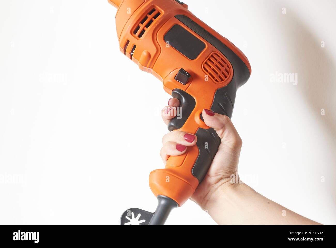 Mujer manicura mano sosteniendo una herramienta eléctrica, un taladro de  fuerza naranja. Fondo blanco con espacio de copia Fotografía de stock -  Alamy