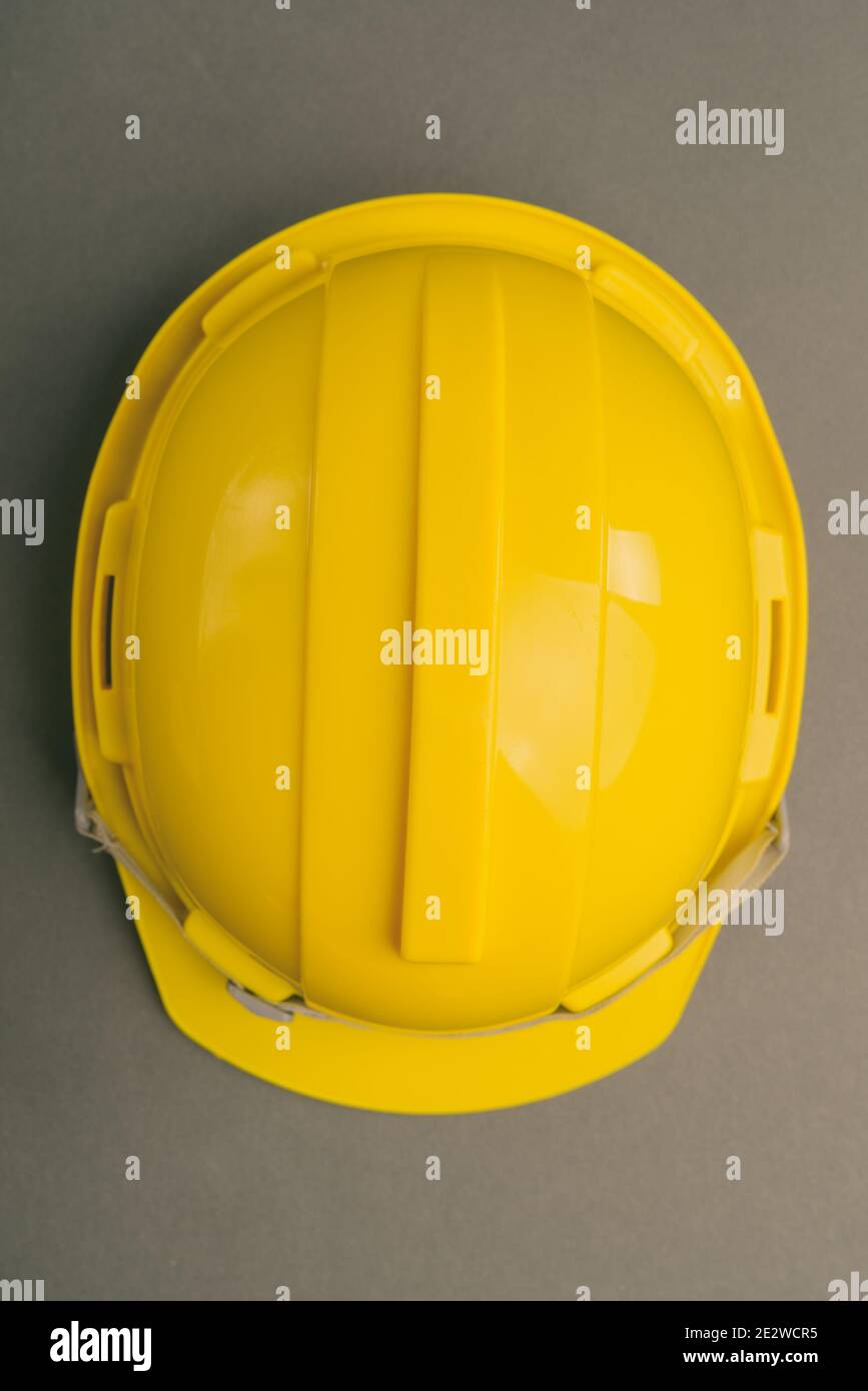 Foto de estudio con fondo blanco de un casco amarillo de obra.