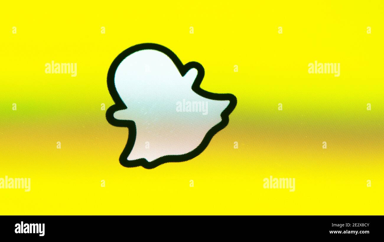 Logotipo de Snapchat fantasma sobre fondo amarillo, pantalla de Apple iPhone. Snapchat es una aplicación de mensajería multimedia desarrollada por Snap Inc Foto de stock