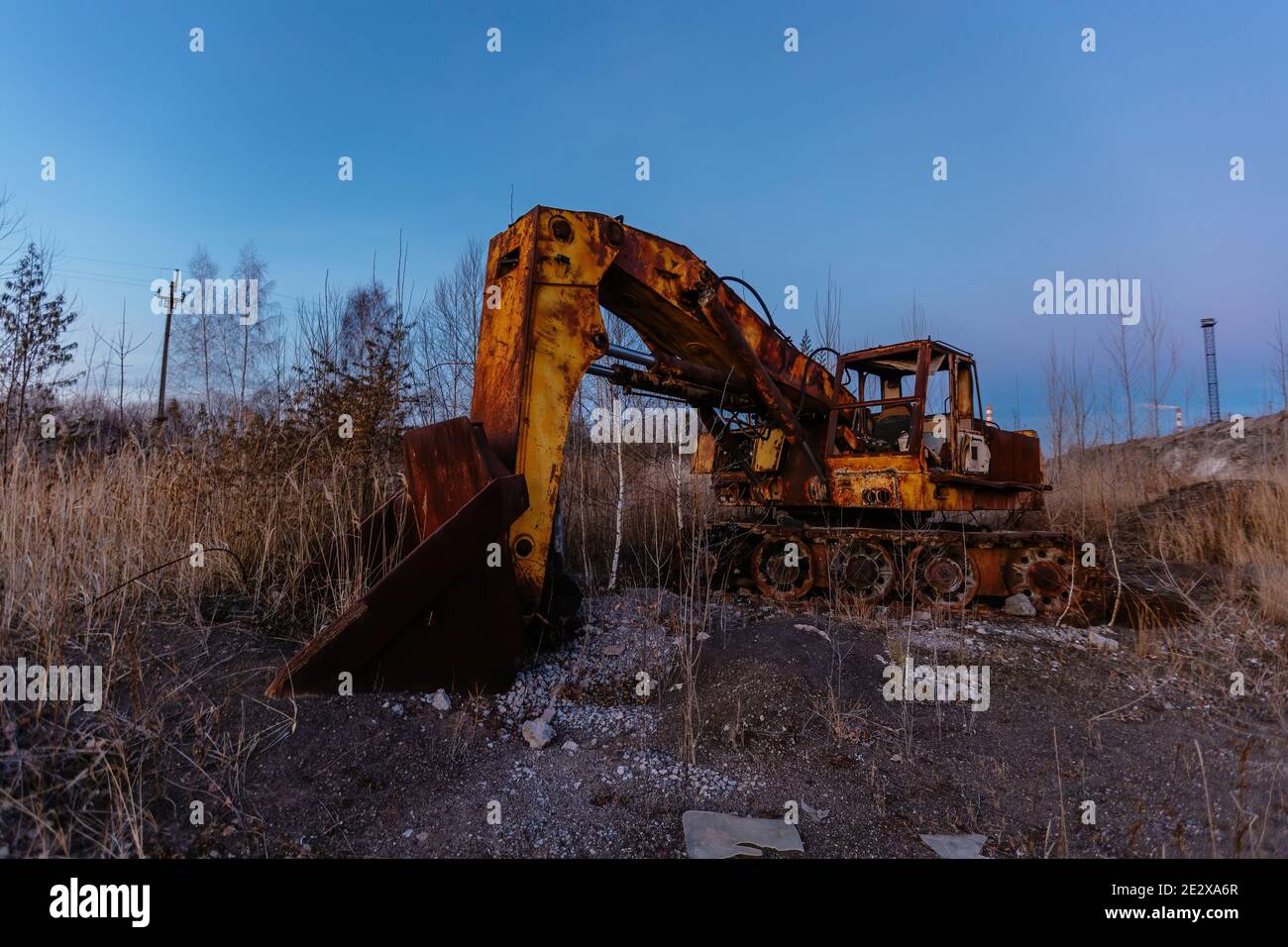 Viejo excavador oxidado abandonado después de cerrar la fábrica. Foto de stock