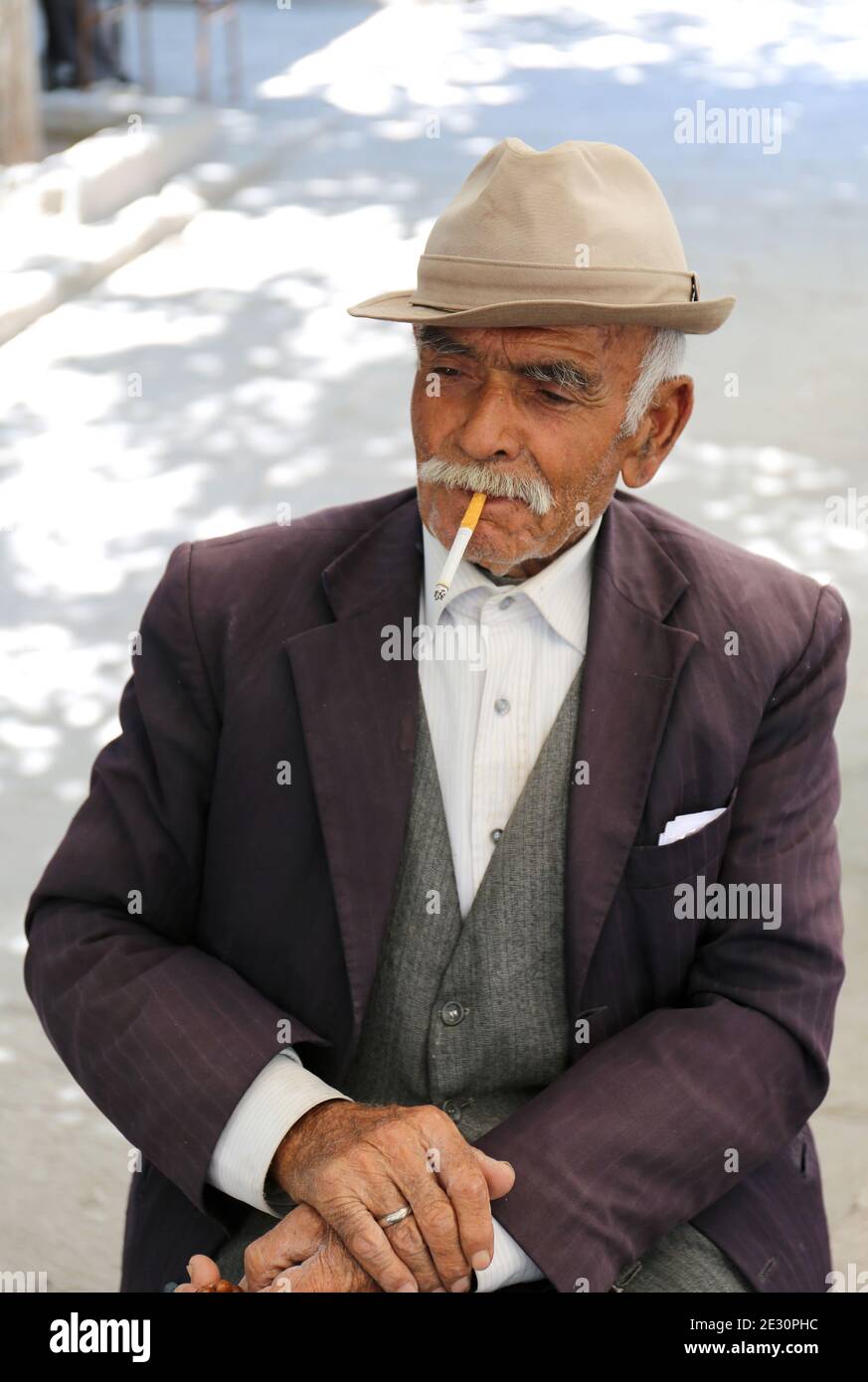 AKSARAY,TURQUÍA-JULIO 22:Viejo caballero turco con cigarrillo y sombrero posando en la casa de té local.Julio 22,2017 en Aksaray,Turquía. Foto de stock